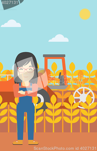 Image of Woman standing with combine on background.