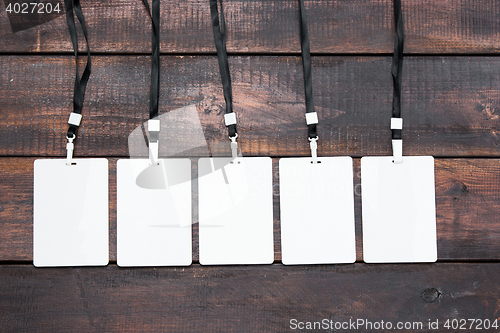 Image of The five card badges with ropes on wooden table