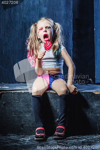 Image of The funny crasy girl with candy on dark background