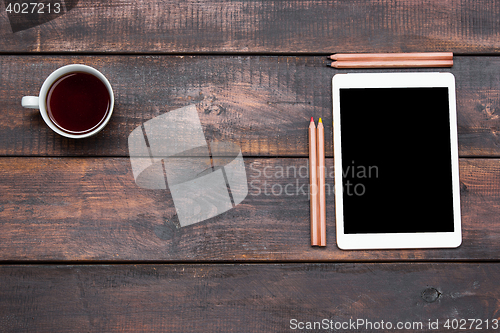 Image of Office desk table with laptop, pencils and coffee cup.