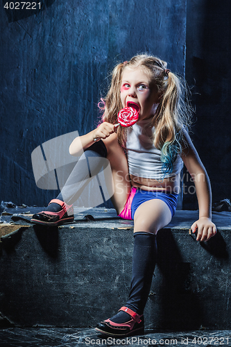 Image of The funny crasy girl with candy on dark background