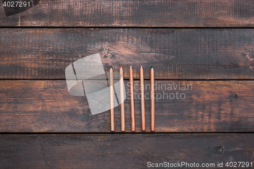 Image of Colored wooden pencils on a wooden old background.