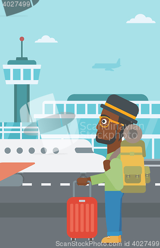Image of Man at the airport with suitcase.
