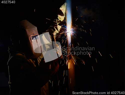 Image of welder worker welding metal by electrode