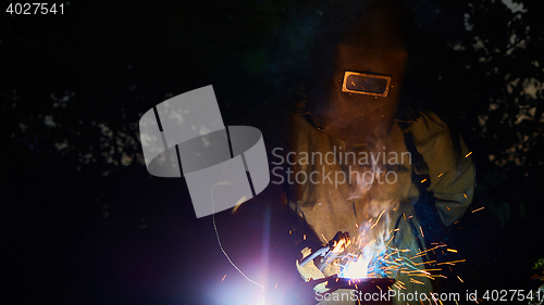 Image of welder worker welding metal by electrode