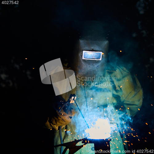 Image of welder worker welding metal by electrode