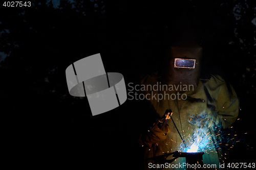 Image of welder worker welding metal by electrode