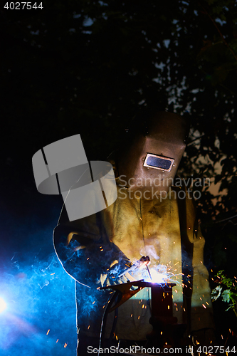 Image of welder worker welding metal by electrode