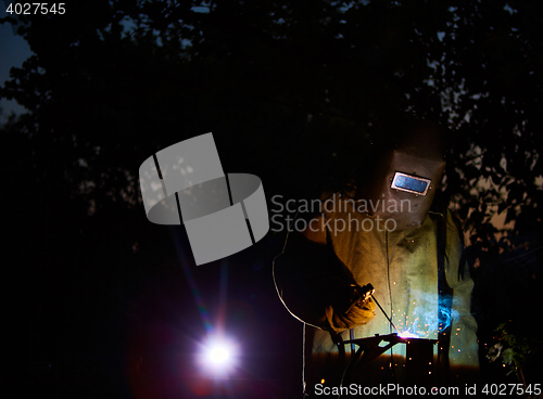 Image of welder worker welding metal by electrode