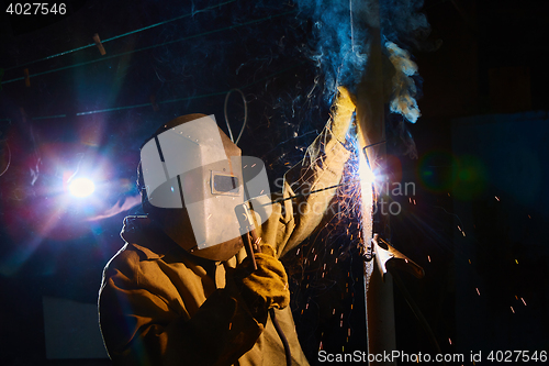 Image of welder worker welding metal by electrode