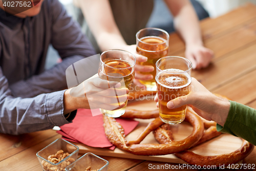 Image of close up of hands clinking beer at bar or pub