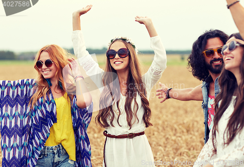 Image of happy young hippie friends dancing on cereal field