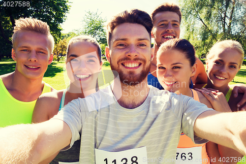 Image of happy friends taking selfie with smartphone
