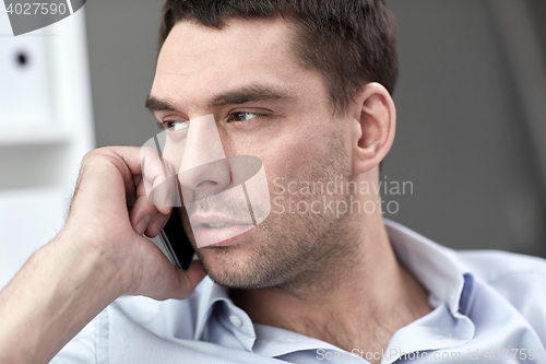 Image of face of young businessman calling on smartphone