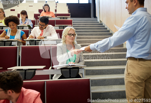 Image of teacher giving exam tests to students at lecture