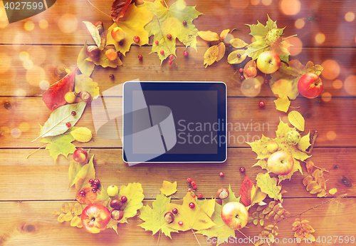 Image of tablet pc with autumn leaves, fruits and berries