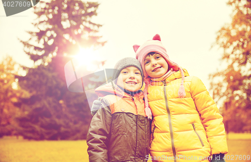 Image of happy little girl and boy in autumn park