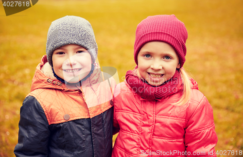 Image of happy little girl and boy in autumn park