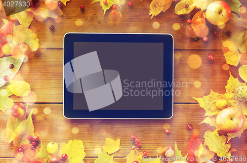 Image of tablet pc with autumn leaves, fruits and berries