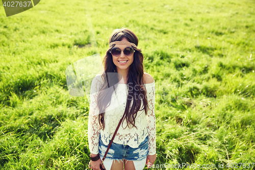 Image of smiling young hippie woman on green field