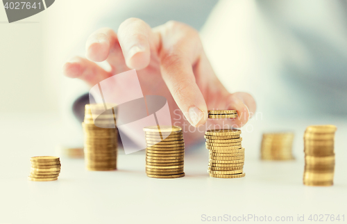 Image of close up of female hand putting coins into columns