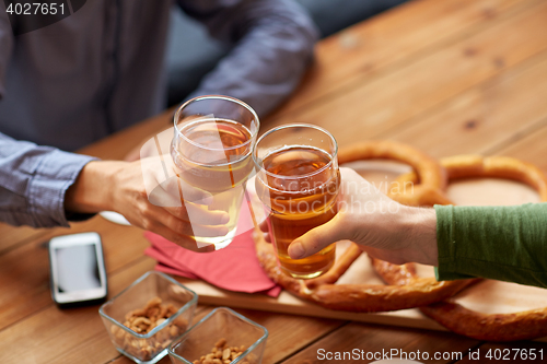 Image of close up of hands clinking beer at bar or pub