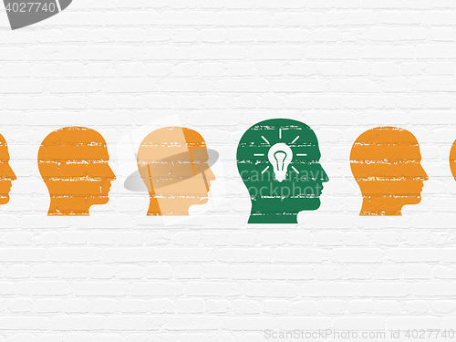 Image of Business concept: head with light bulb icon on wall background