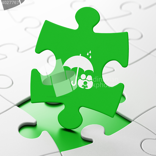 Image of Security concept: Family And Umbrella on puzzle background