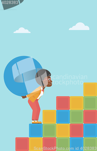 Image of Woman carrying concrete ball uphill.