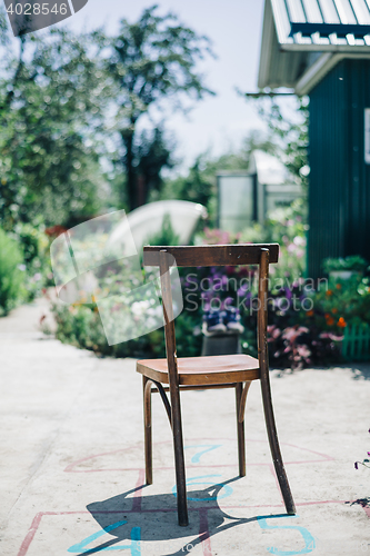 Image of Old wooden chair on asphalt against of garden