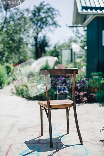 Image of Old wooden chair on asphalt against of garden