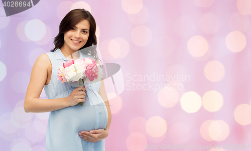 Image of happy pregnant woman with flowers touching belly