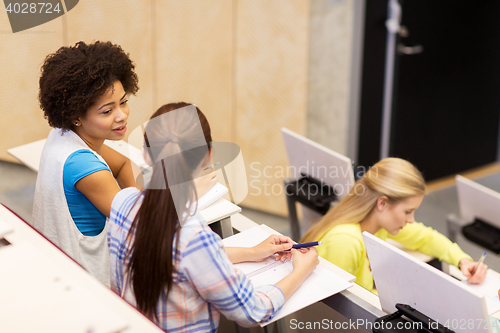 Image of group of students talking in lecture hall