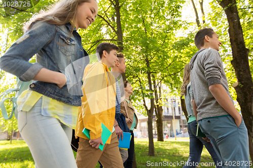 Image of group of happy teenage students walking outdoors