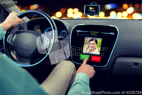 Image of close up of man driving car and receiving call