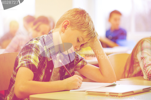 Image of group of school kids writing test in classroom