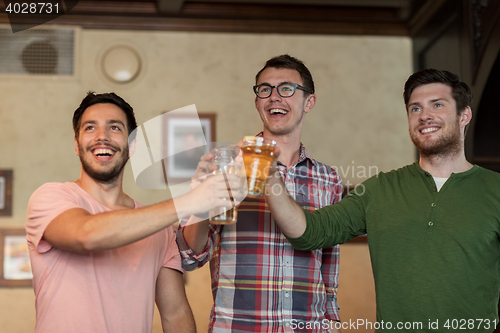 Image of happy male friends drinking beer at bar or pub