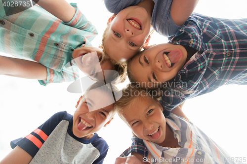 Image of group of happy children showing tongue in circle