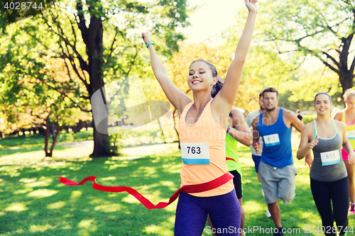 Image of happy young female runner winning on race finish