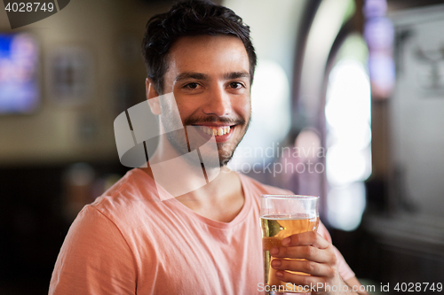 Image of happy man drinking beer at bar or pub