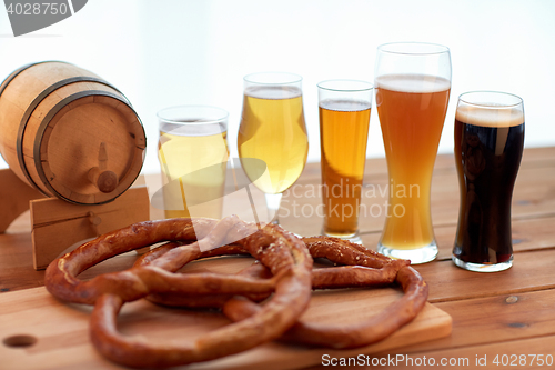 Image of close up of beer glasses, barrel and pretzels