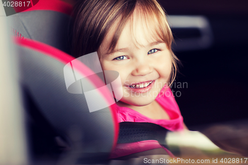 Image of happy little girl sitting in baby car seat