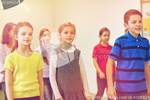 Image of group of smiling school kids walking in corridor