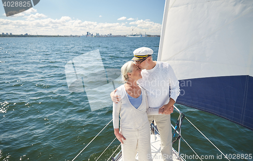 Image of senior couple kissing on sail boat or yacht in sea