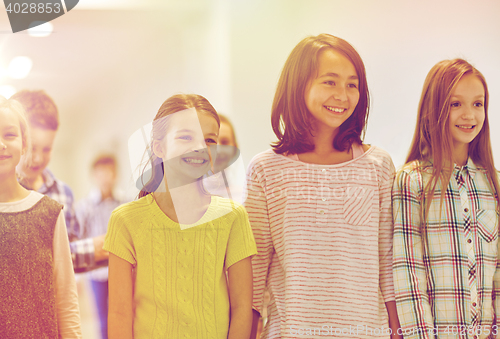 Image of group of smiling school kids walking in corridor