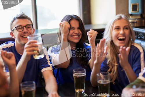 Image of football fans or friends with beer at sport bar