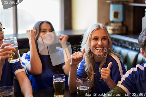 Image of football fans or friends with beer at sport bar