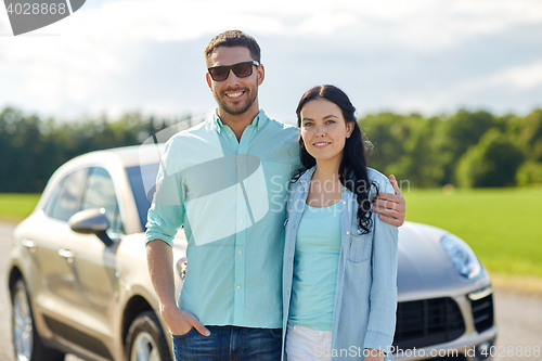 Image of happy man and woman hugging at car