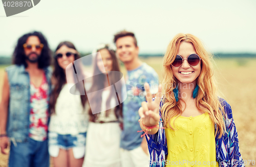 Image of happy young hippie friends showing peace outdoors