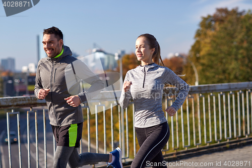 Image of happy couple running outdoors